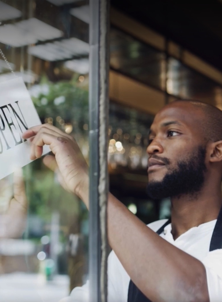 Image of a store owner flipping the open/closed sign